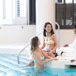 A group lounges by the pool between spa services at Elmwood Spa