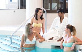 A group lounges by the pool between spa services at Elmwood Spa