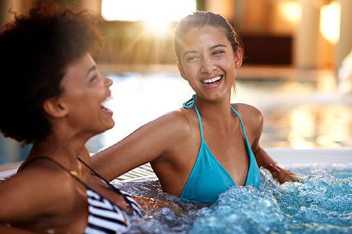 Two friends enjoy a laugh in the hot tub at Elmwood Spa